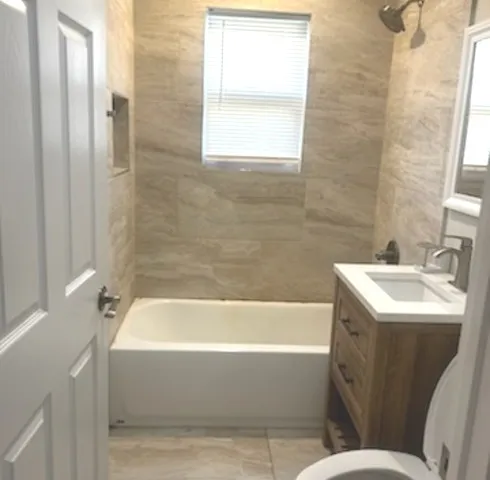 a bathroom with a sink mirror bathtub and toilet