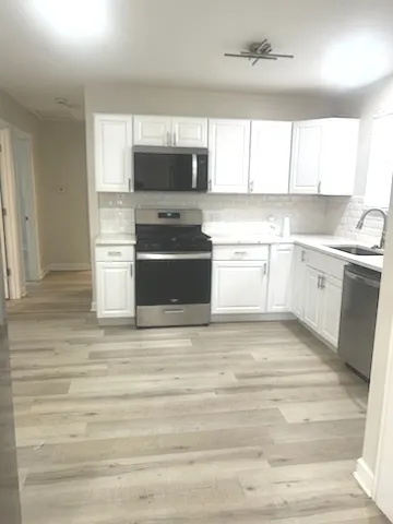 a kitchen with stainless steel appliances granite countertop a stove a sink and a microwave