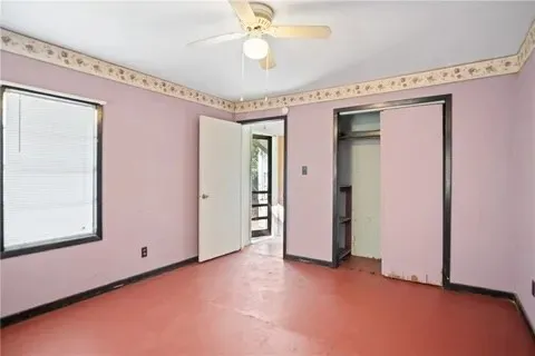 a view of a hallway with a window and chandelier fan