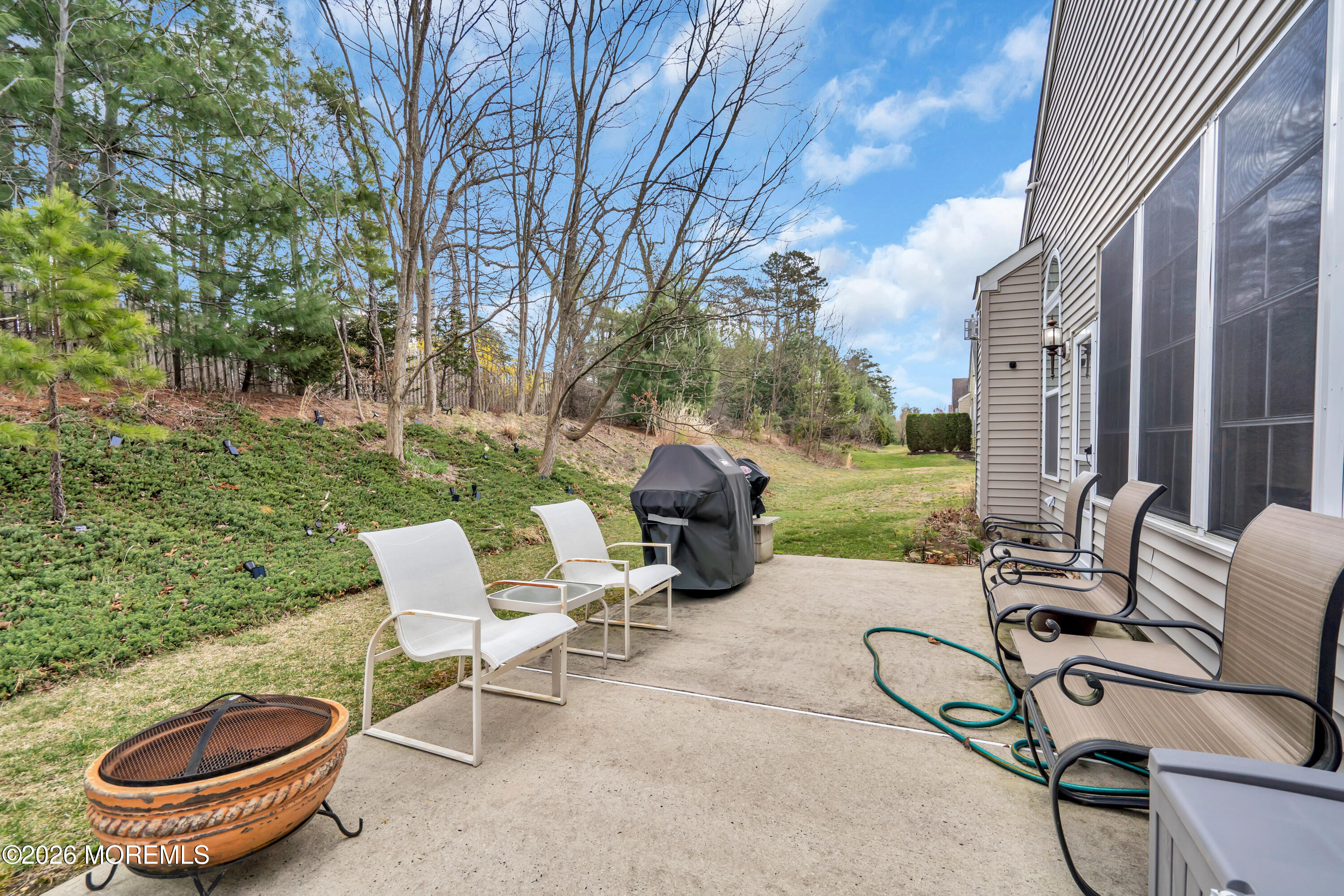 15 Enclave Boulevard Lakewood, NJ 08701 - Photo 71 of 81 a view of a patio with chairs and a table and chairs with wooden fence