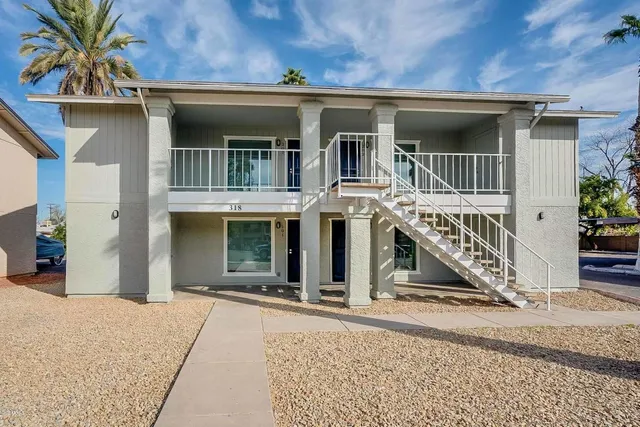 a view of a house with large windows and a small yard