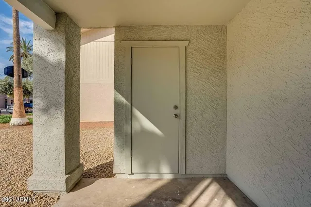 an empty room with wooden floor chandelier fan and windows
