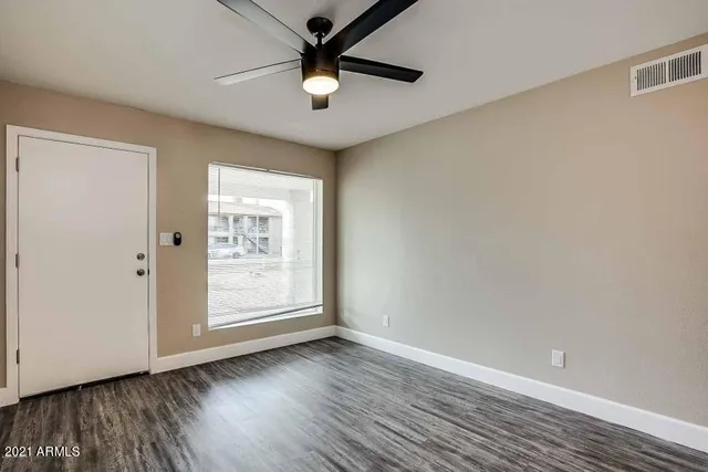 a kitchen with a refrigerator and wooden floor