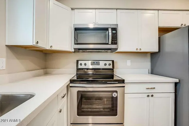 a kitchen with stainless steel appliances a refrigerator stove and microwave