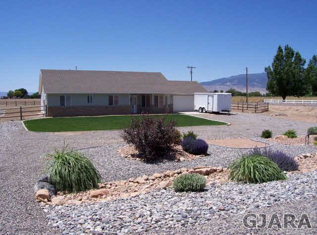 20258 Fox Ridge Drive Austin, CO 81410 - Photo 1 of 6 a front view of a house with garden