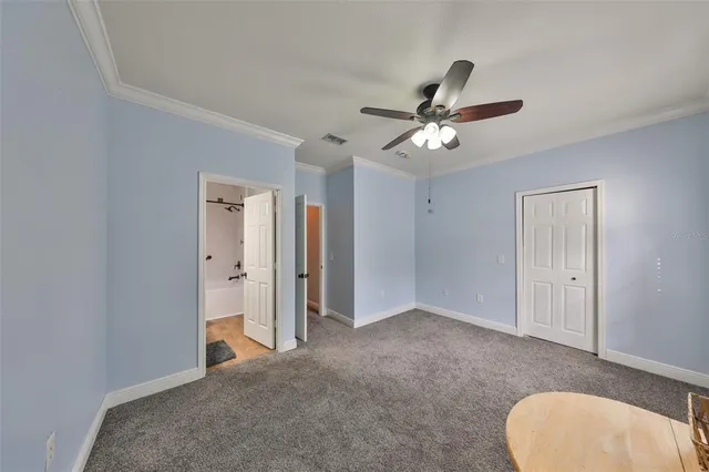 an empty room with a ceiling fan and a window
