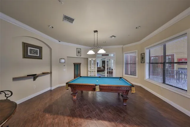 a room with pool table and windows