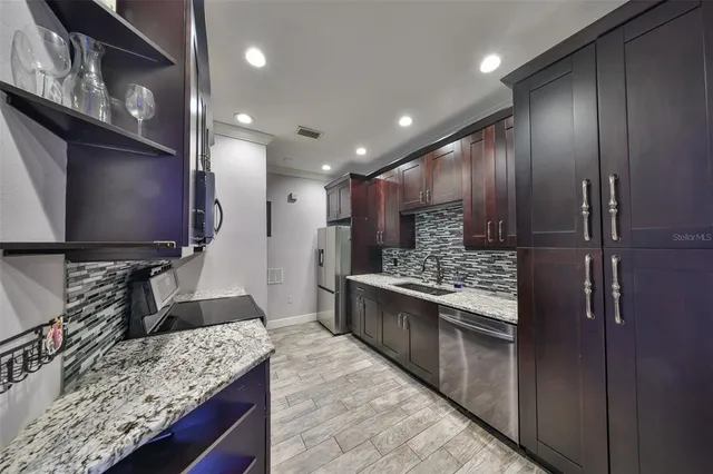 a kitchen with stainless steel appliances granite countertop a sink stove and refrigerator