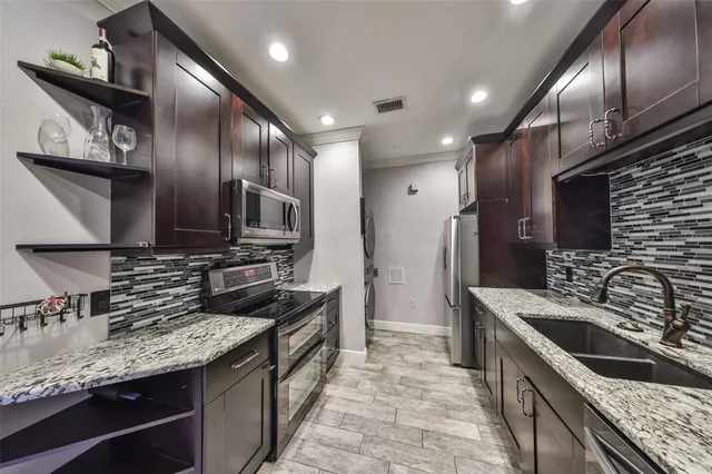 a kitchen with stainless steel appliances granite countertop a sink stove and refrigerator
