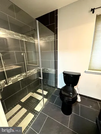 a bathroom with a toilet and a shower