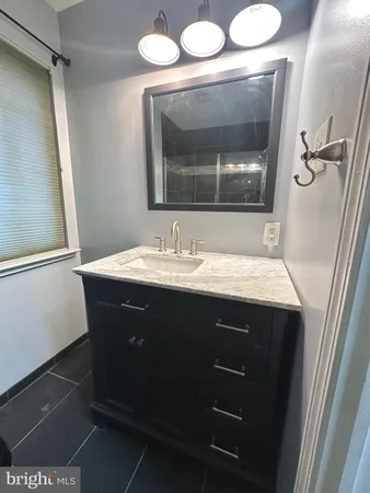 a bathroom with a sink vanity and a mirror