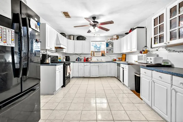 a large kitchen with stainless steel appliances lots of counter space cabinets and furniture