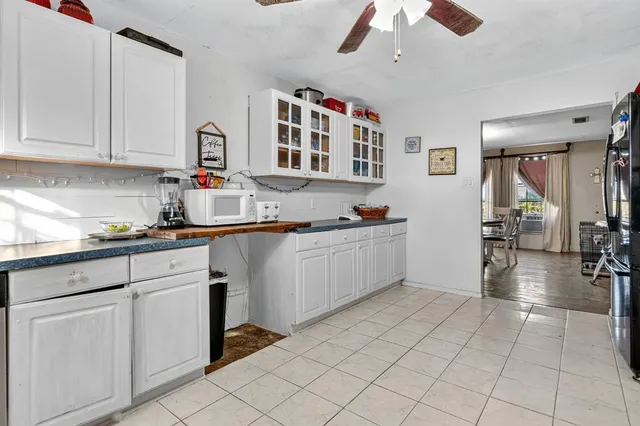 a kitchen with cabinets and chairs