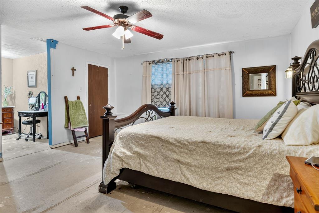 511 Salt Creek Road Poolville, TX 76487 - Photo 19 of 29 a bedroom with a bed and a chandelier