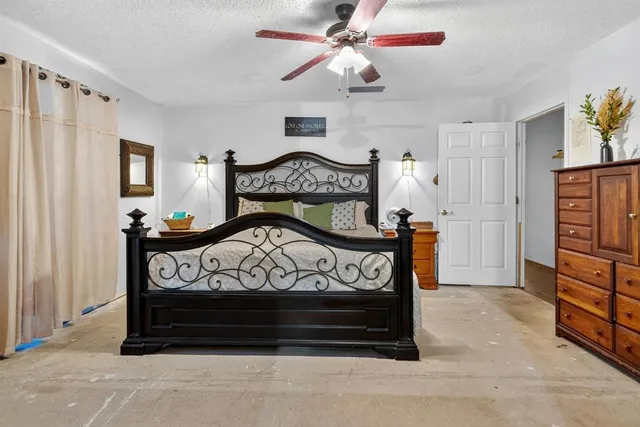 a view of a bedroom with furniture and a chandelier fan