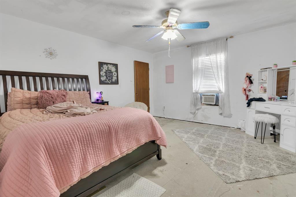 511 Salt Creek Road Poolville, TX 76487 - Photo 22 of 29 a bedroom with a balcony a bed and a chandelier