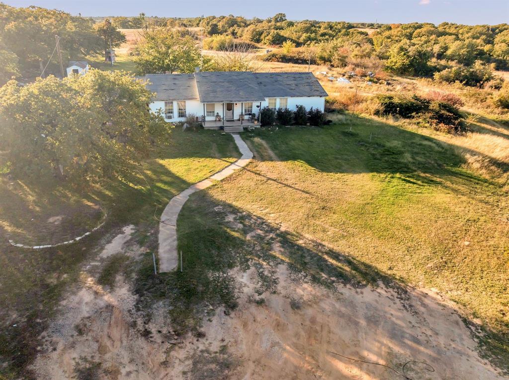 511 Salt Creek Road Poolville, TX 76487 - Photo 24 of 29 a view of a house with a yard and a large tree
