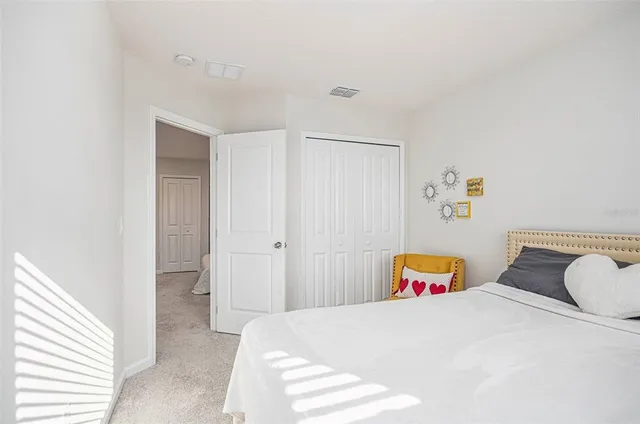 a bedroom with a bed and painting on the wall