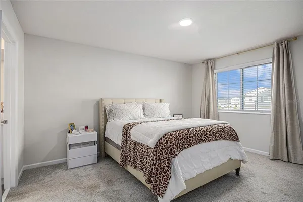 a bed sitting in a bedroom next to a window