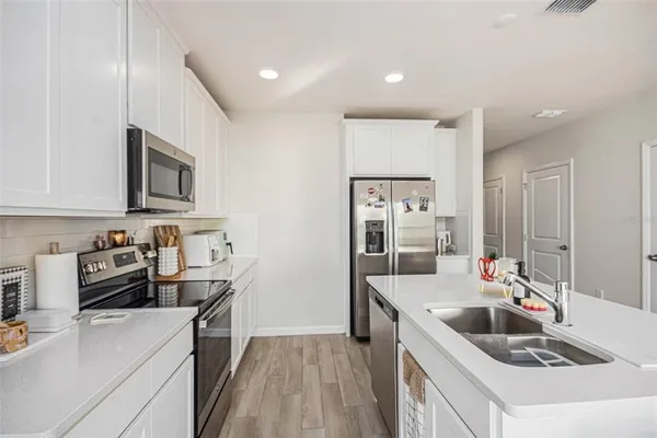 a kitchen with stainless steel appliances a sink stove and refrigerator