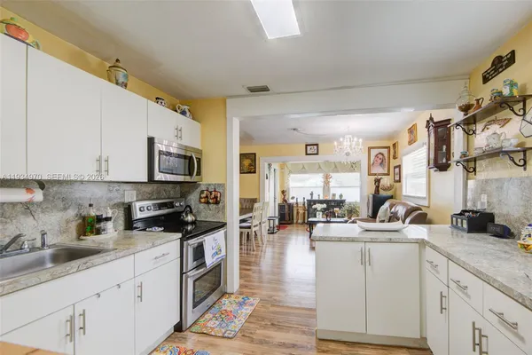 a kitchen with counter top space a sink cabinets and appliances