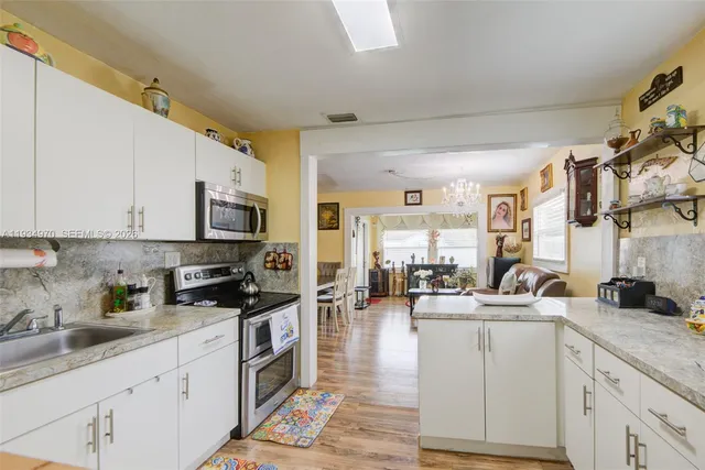 a kitchen with counter top space a sink cabinets and appliances