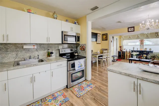 a kitchen with stainless steel appliances granite countertop a refrigerator sink and cabinets