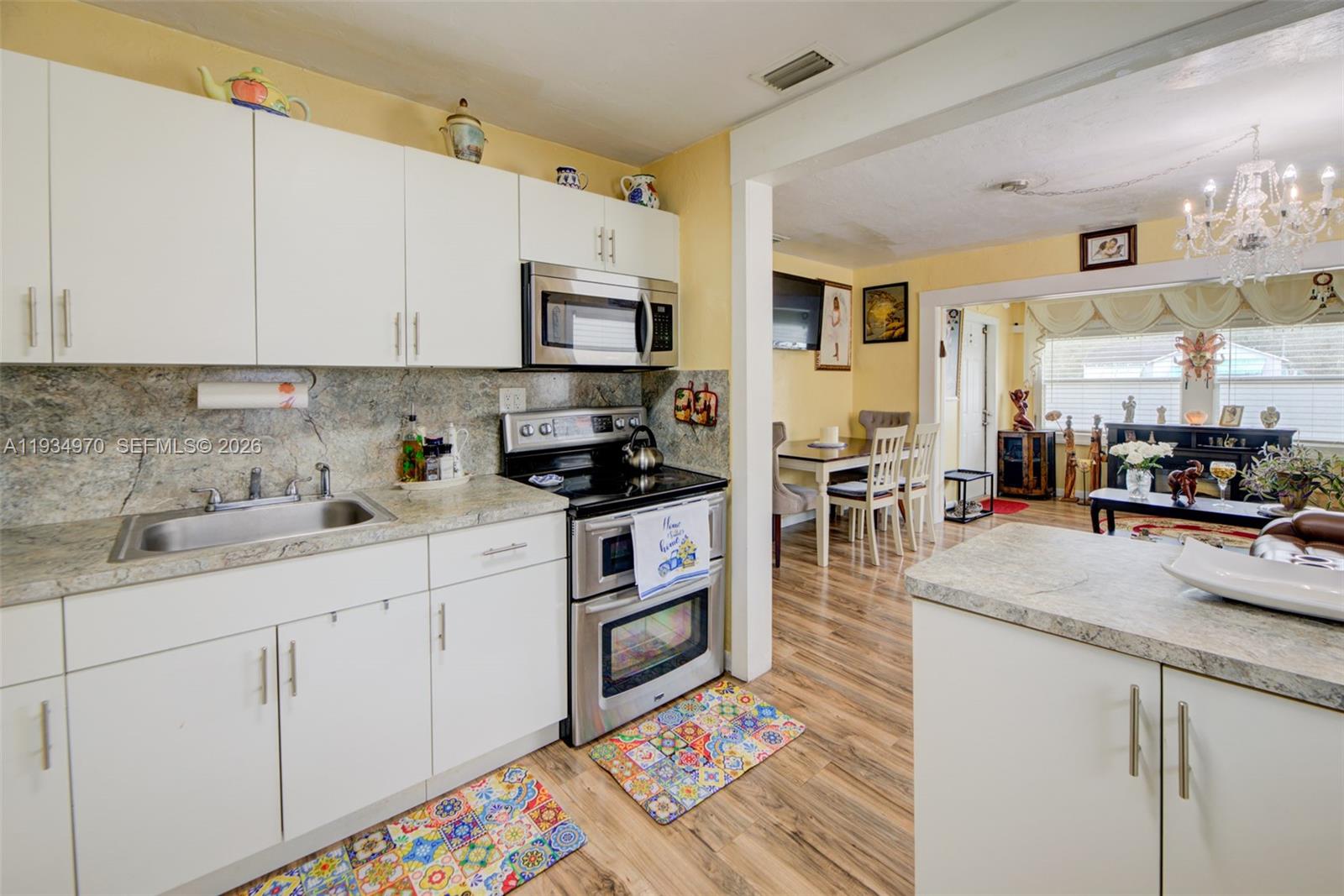 1911 Northwest 52nd Street Miami, FL 33142 - Photo 12 of 48 a kitchen with stainless steel appliances granite countertop a refrigerator sink and cabinets
