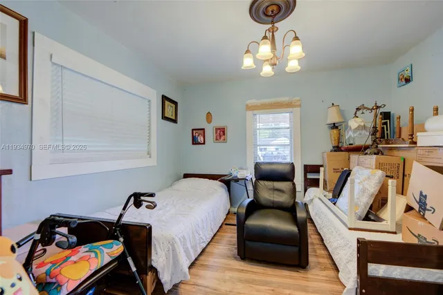 a bedroom with a bed and a flat tv screen on the dresser