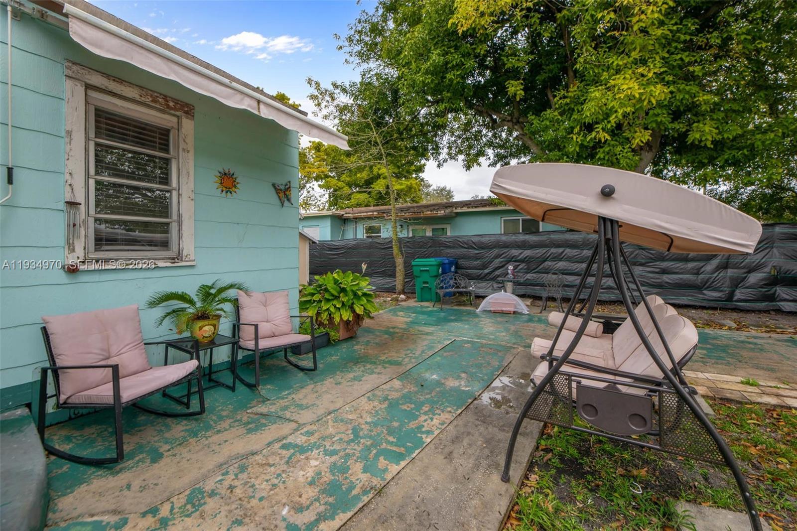 1911 Northwest 52nd Street Miami, FL 33142 - Photo 26 of 48 a backyard of a house with table and chairs