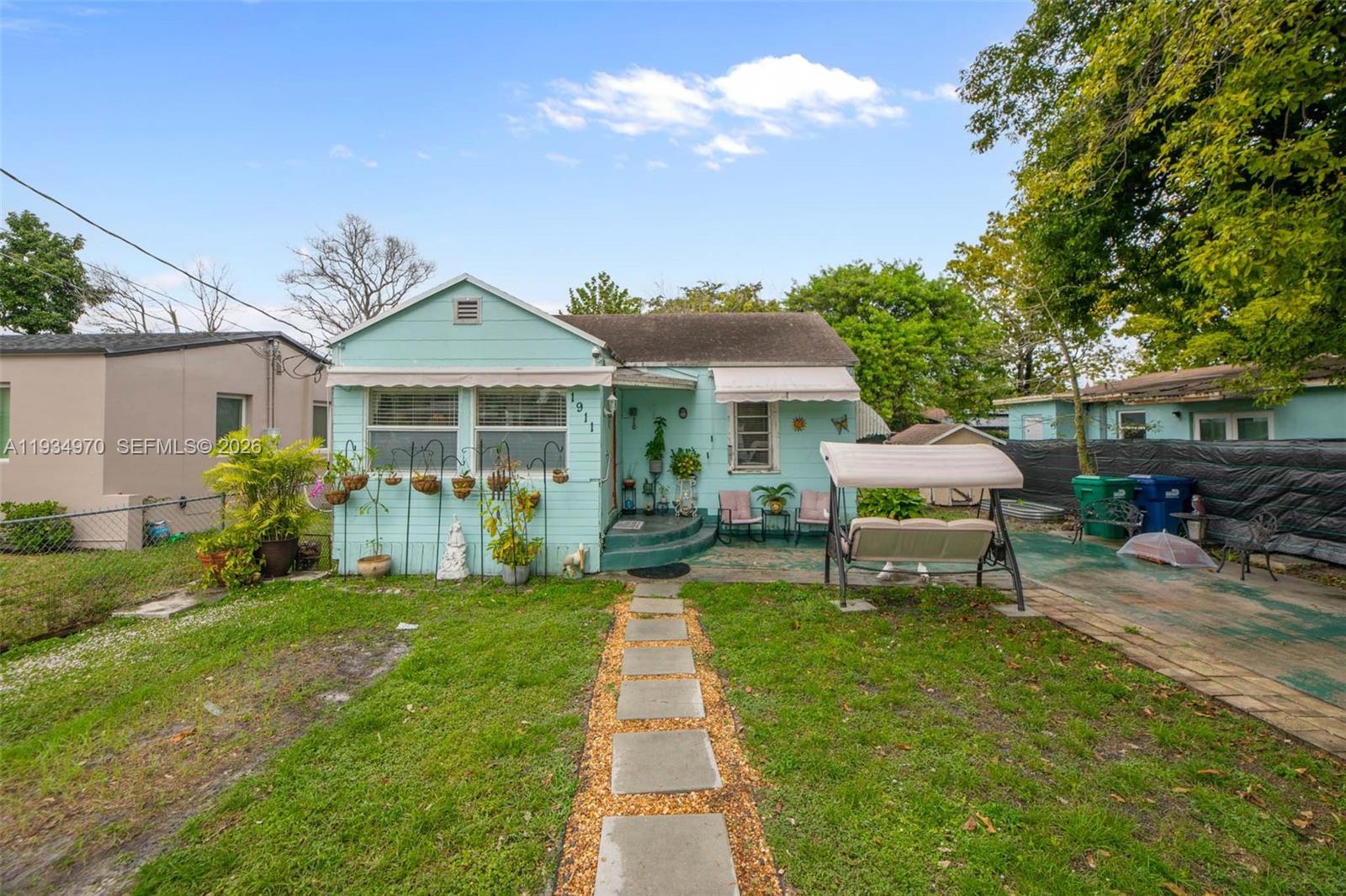 1911 Northwest 52nd Street Miami, FL 33142 - Photo 34 of 48 a backyard of a house with table and chairs