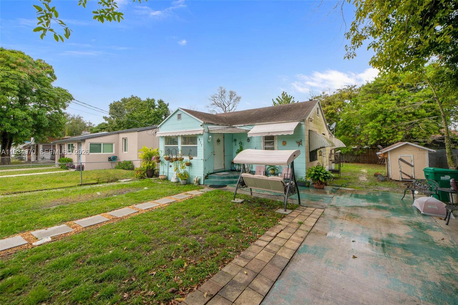 1911 Northwest 52nd Street Miami, FL 33142 - Photo 35 of 48 a house view with a sitting space and garden