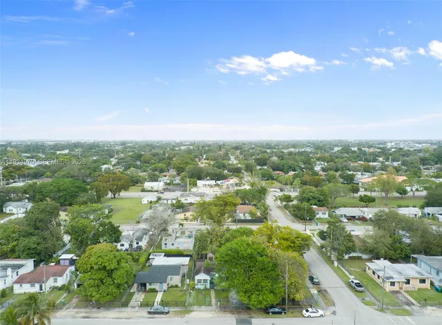 an aerial view of residential houses with outdoor space and trees