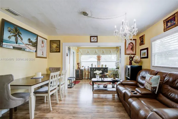 a living room with furniture or chandelier and a wooden floor