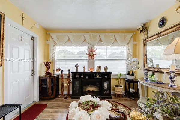 a living room with fireplace furniture and a large window