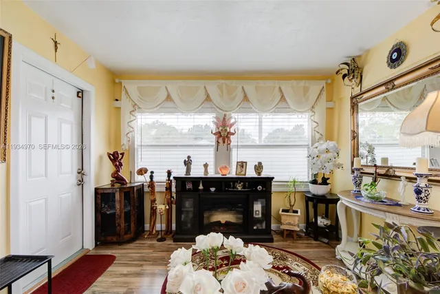 a living room with fireplace furniture and a large window