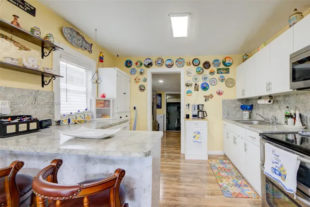 a kitchen with stainless steel appliances kitchen island granite countertop a sink and cabinets