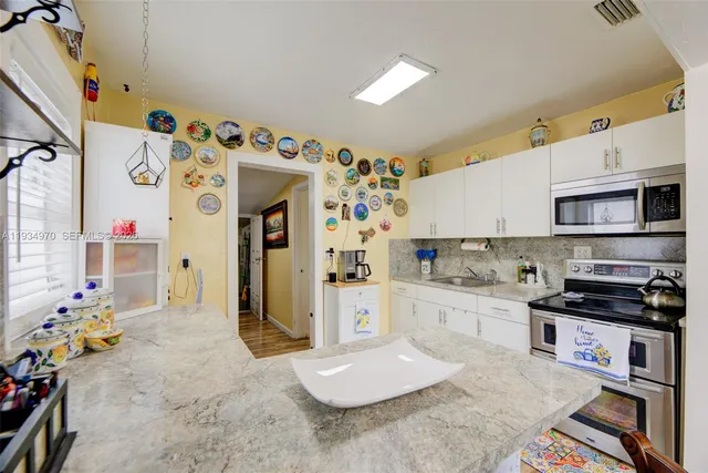 a kitchen with stainless steel appliances granite countertop a refrigerator and stove