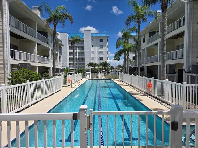 a house view with a swimming pool and wooden deck