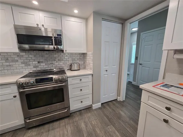 a kitchen with granite countertop a refrigerator stove and sink
