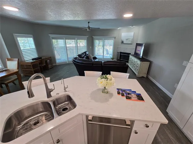 a kitchen with kitchen island stainless steel appliances a sink a table and chairs