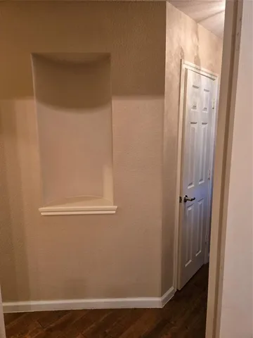 a view of a hallway with wooden floor and staircase