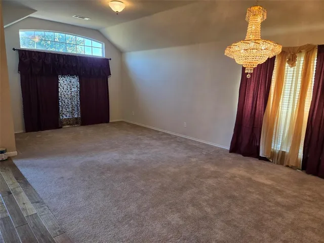 an empty room with windows and fireplace