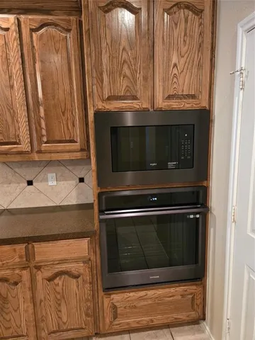 a kitchen with granite countertop white cabinets and stainless steel appliances