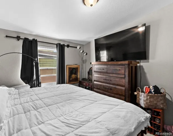 a bedroom with a bed and a flat screen tv