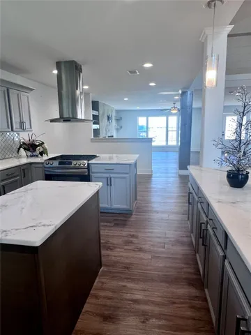 a kitchen with stainless steel appliances granite countertop a sink a stove and a wooden floors