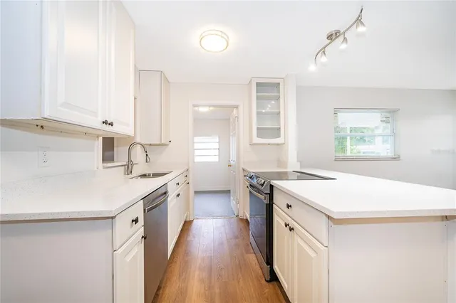 a kitchen with a sink a stove a refrigerator and a window