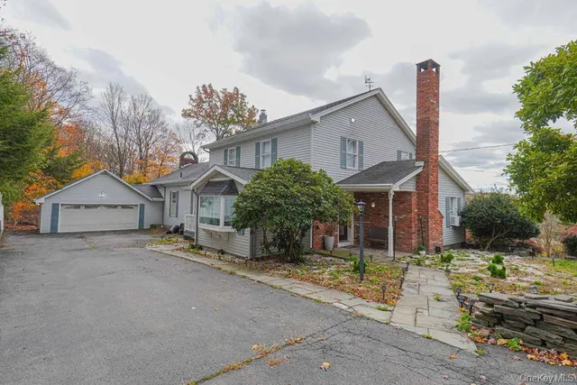 a view of a house with a yard and large tree