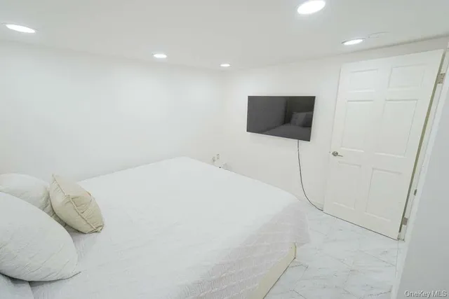 a bedroom with a bed and a flat screen tv