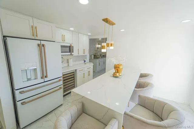 a kitchen with stainless steel appliances refrigerator wooden floor and couch